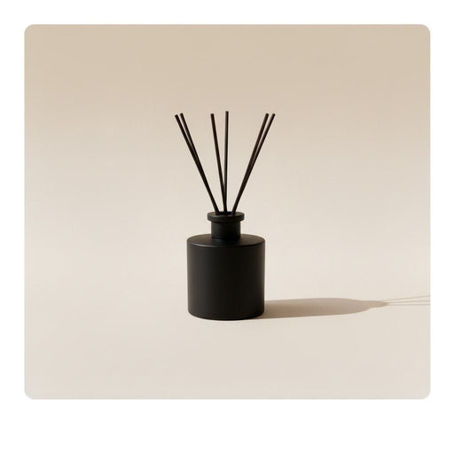 Shelves displaying Votivo candles and reed diffusers in elegant packaging. The products are primarily in blue and gold colors, including scents like Icy Blue Pine and Spiced Chai, with a warm, inviting atmosphere.