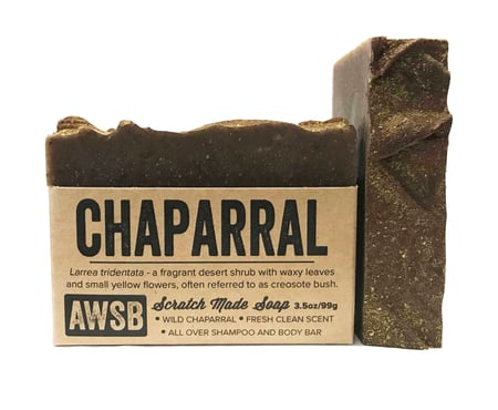 A Wild Soap Bars Chaparral soap, featuring a brown, textured surface and weighing 3.5oz/99g, is an antimicrobial shampoo and body bar with a fresh scent of wild chaparral for a refreshing cleanse.