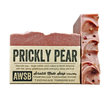 A Wild Soap Bar - Prickly Pear by AWSB is a pink exfoliating bar with scratch-made purifying clay, soothing aloe vera, and an energizing scent, featuring a textured top for exfoliation.