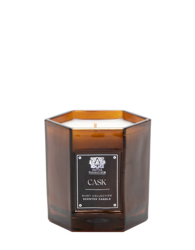 The Antica Farmacista - Cask 9oz Candle features a hexagonal amber glass design from the Rivet Collection. With one visible wick and a decorative emblem on its label, it promises to enhance any space with elegance and delightful fragrance.