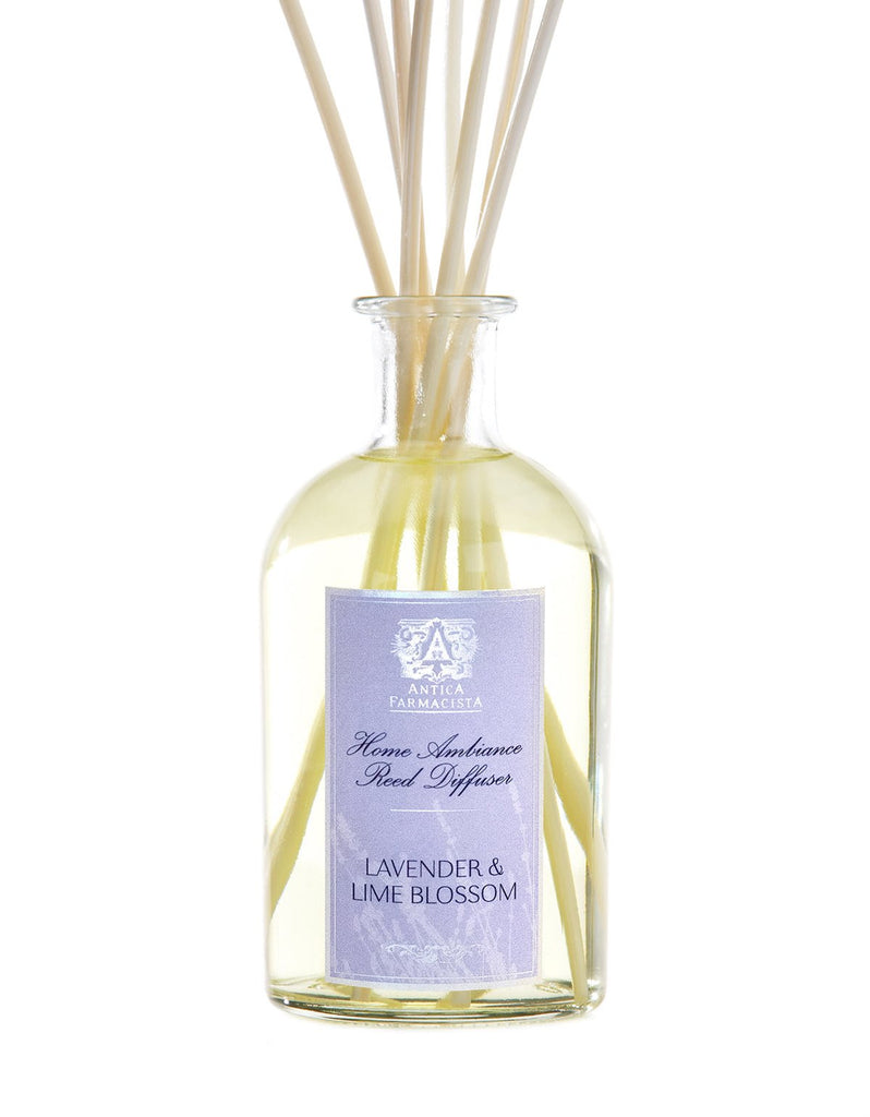 The Antica Farmacista Lavender & Lime Blossom 250ml Reed Diffuser features a glass bottle with reeds at the top, filled with a light yellow liquid subtly infused with lime blossom essence.