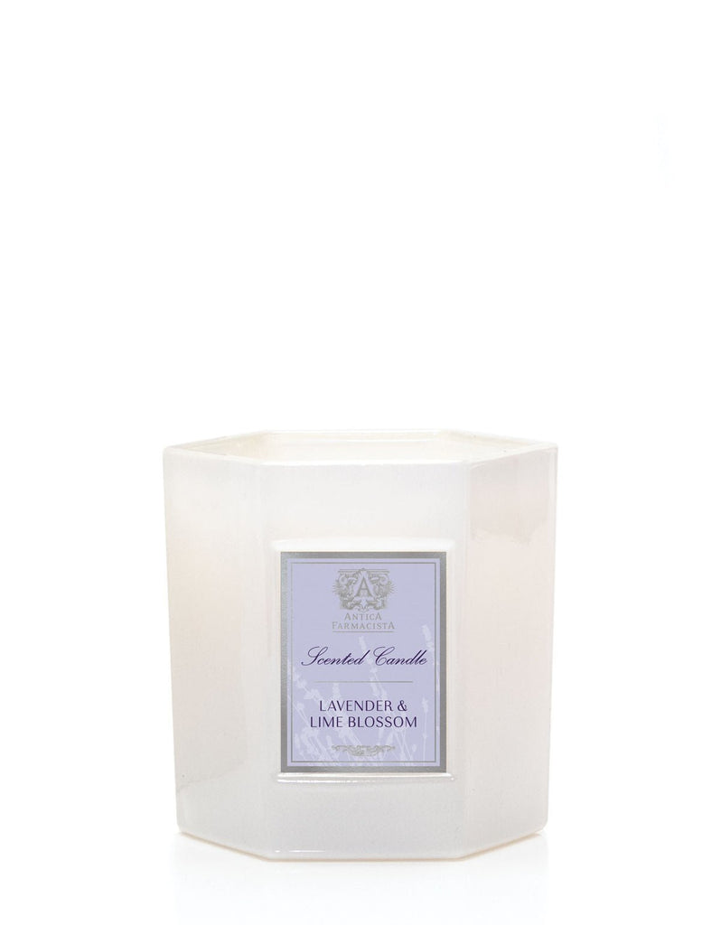 The Antica Farmacista - Lavender & Lime Blossom 9oz Candle is a white hexagonal candle made from soy-paraffin wax, featuring a label with the Lavender & Lime Blossom scent on a plain white background.