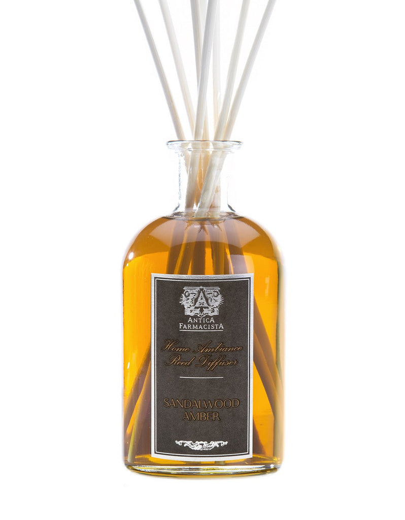 A 250ml glass bottle filled with amber liquid labeled Antica Farmacista has reeds that release a captivating fragrance, marking it as the Sandalwood Amber Reed Diffuser.