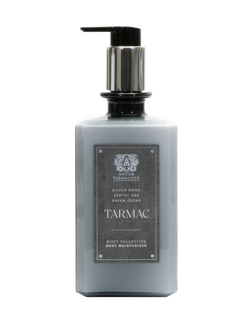 The Antica Farmacista - Tarmac Body Moisturizer 16oz features a scent with silver wood, earthy oak, and green cedar notes. Made with natural ingredients, it comes with a pump dispenser and a dark gray label.