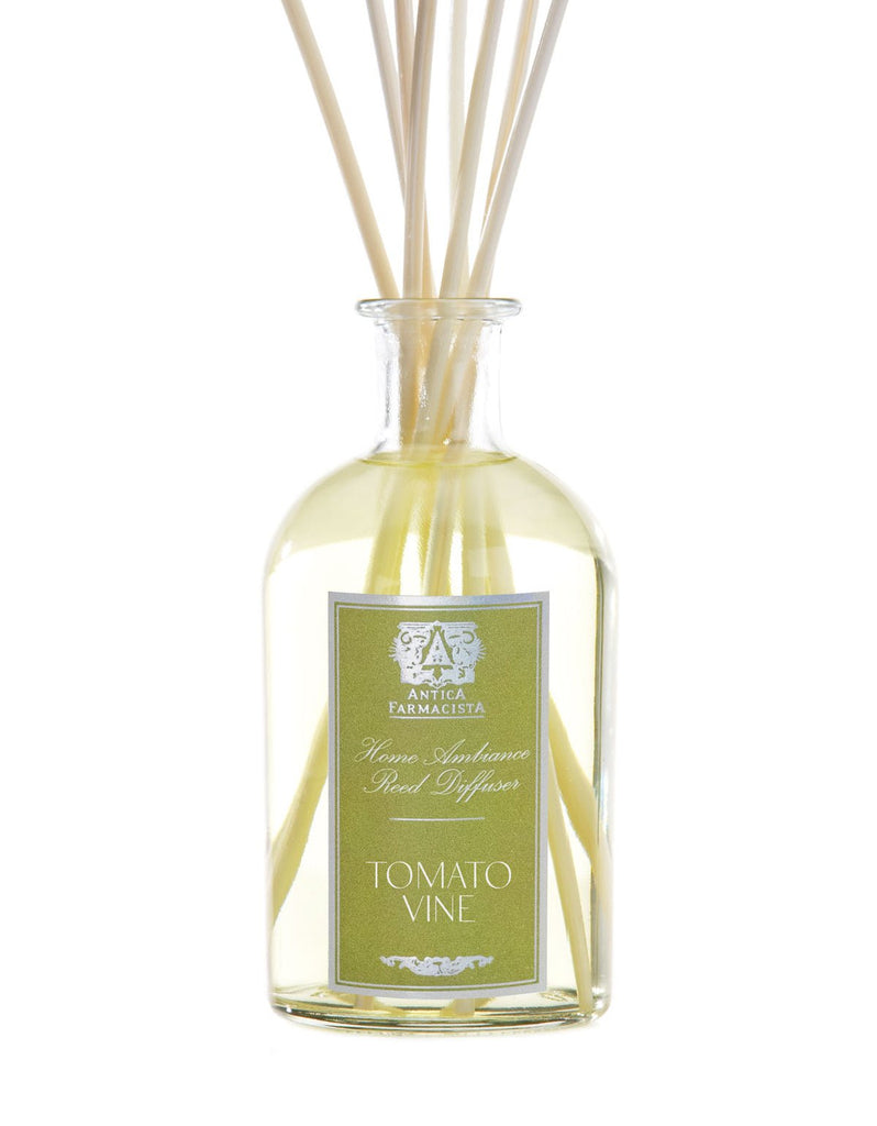 A clear glass bottle labeled Antica Farmacista - Tomato Vine 250ml Reed Diffuser contains light yellow fragrance. Natural reed sticks extend from the bottle, elegantly diffusing the captivating aroma.