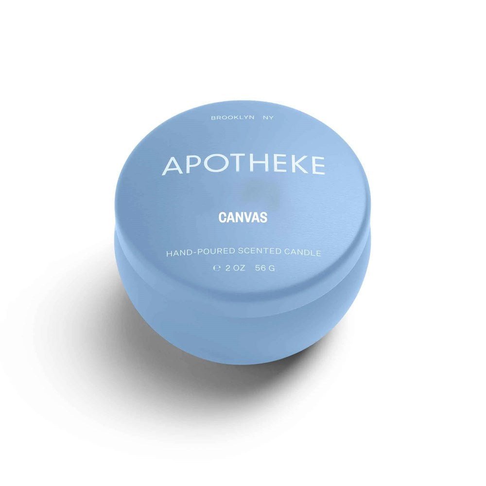 The Apotheke - Canvas Mini Tin 2oz Candle, in light blue with shadow effect, features BROOKLYN NY and APOTHEKE CANVAS on the lid. Made from premium soy wax blend, it offers a delightful floral fragrance in its 2 oz form.