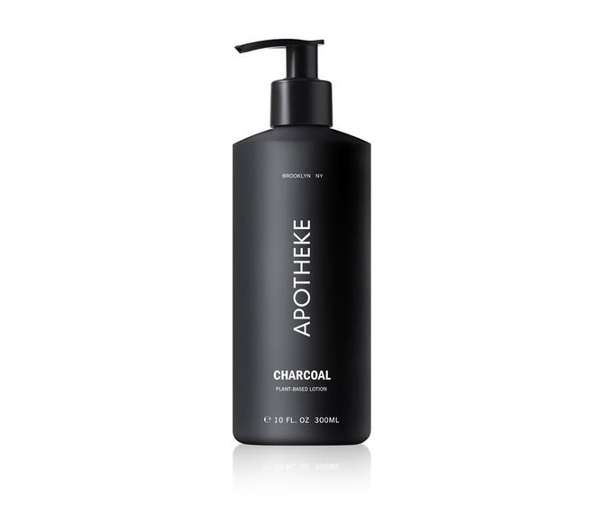 The elegant Apotheke Charcoal Lotion comes in a sleek black bottle with a pump dispenser. Its label shows Brooklyn, NY and 10 FL. OZ 300 ML. Enriched with plant-based ingredients, this moisturizing lotion adds luxury to your daily routine.