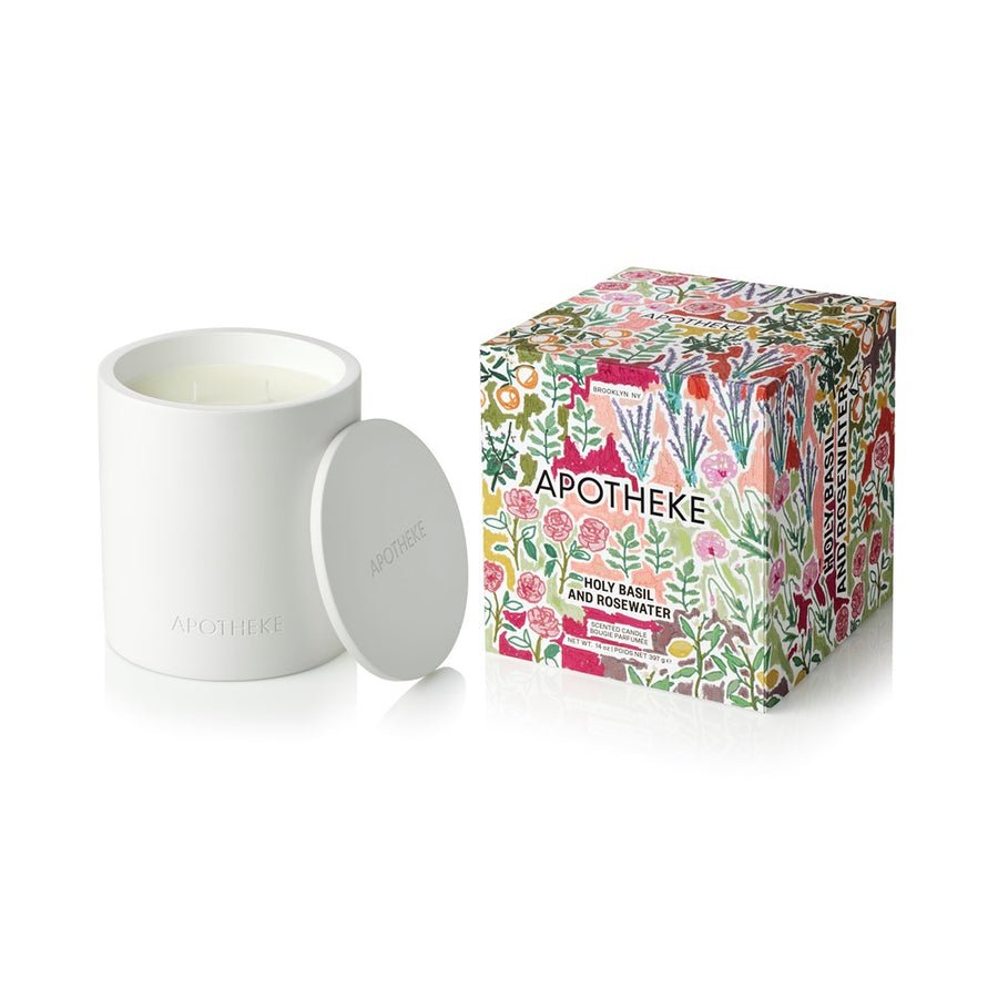 The Apotheke Holy Basil and Rosewater 2 Wick Candle, made from a soy wax blend with essential oils, is shown with a matching lid beside its colorful floral-patterned box on a white background.