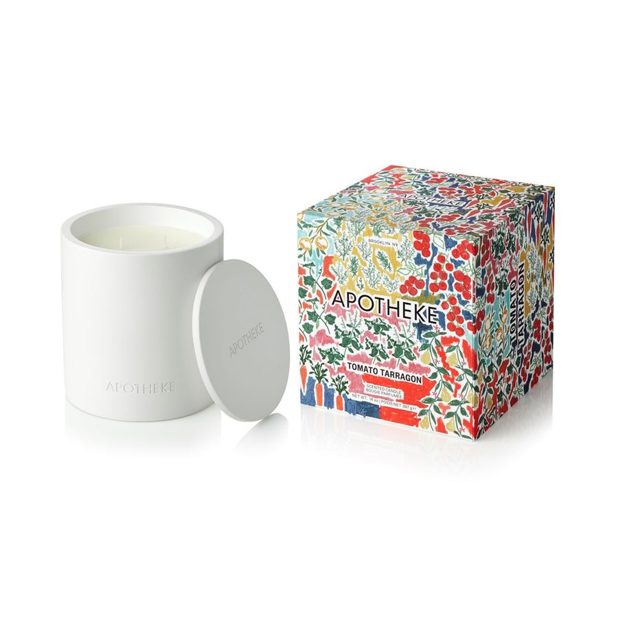 A white Apotheke 2 Wick Candle (Tomato Tarragon) is shown without its lid beside a vibrant, floral-patterned box labeled "Apotheke Tomato Tarragon.