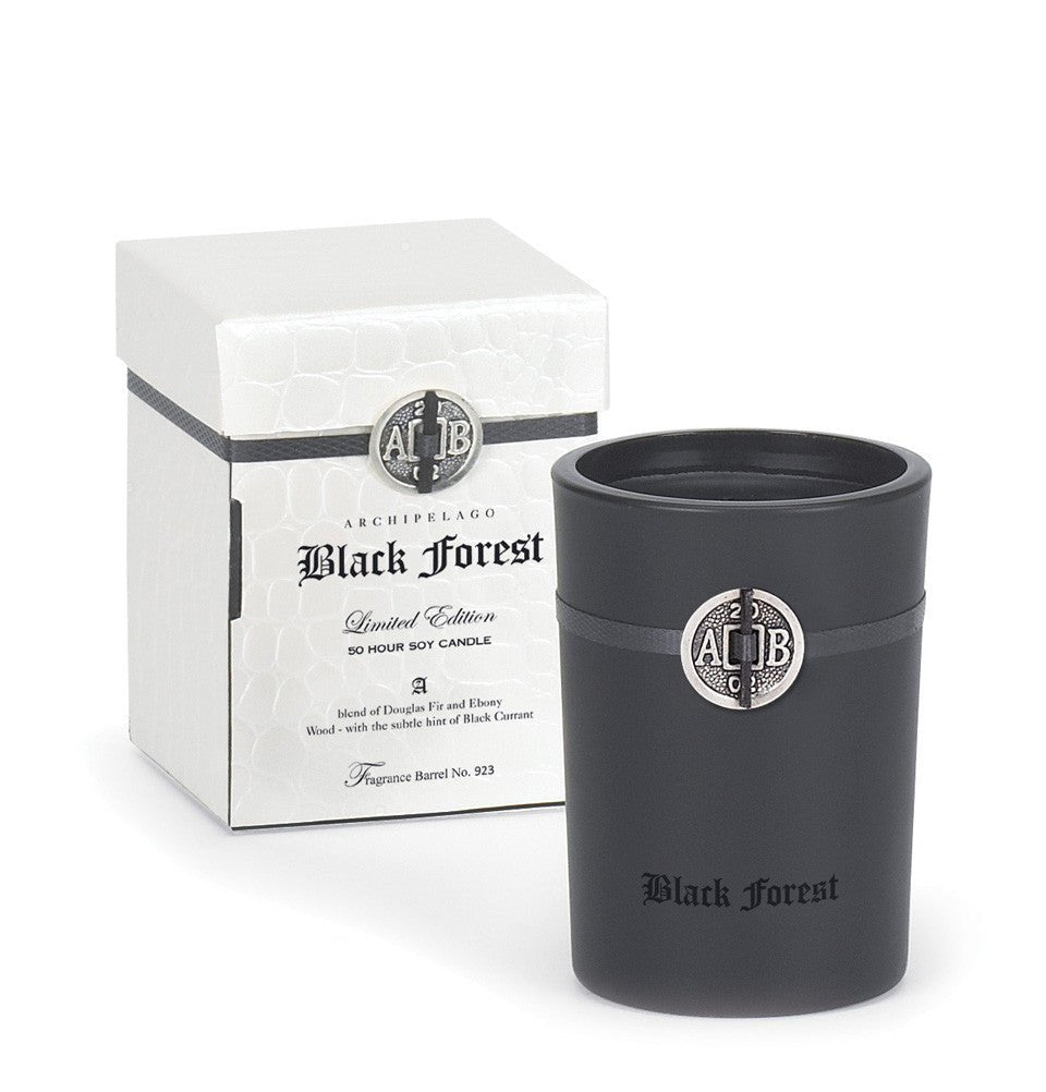 The Archipelago Black Forest Limited Edition features a black candle in its matching holder and a white box, exuding the enchanting fragrance of soy, black currant, and Dark Ebony Woods under the product name Archipelago - Black Forest 5.2oz Boxed Candle.