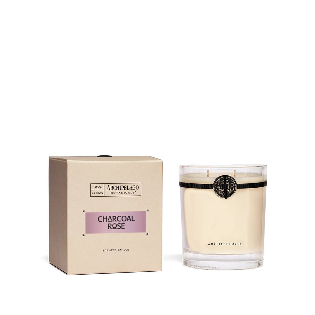 The Archipelago - Charcoal Rose Credenza 10oz Candle, a best-seller, features a cream-colored candle in a glass jar with a black wax seal and an elegant purple label. It exudes a delightful floral fragrance and comes stylishly packaged in its own box.