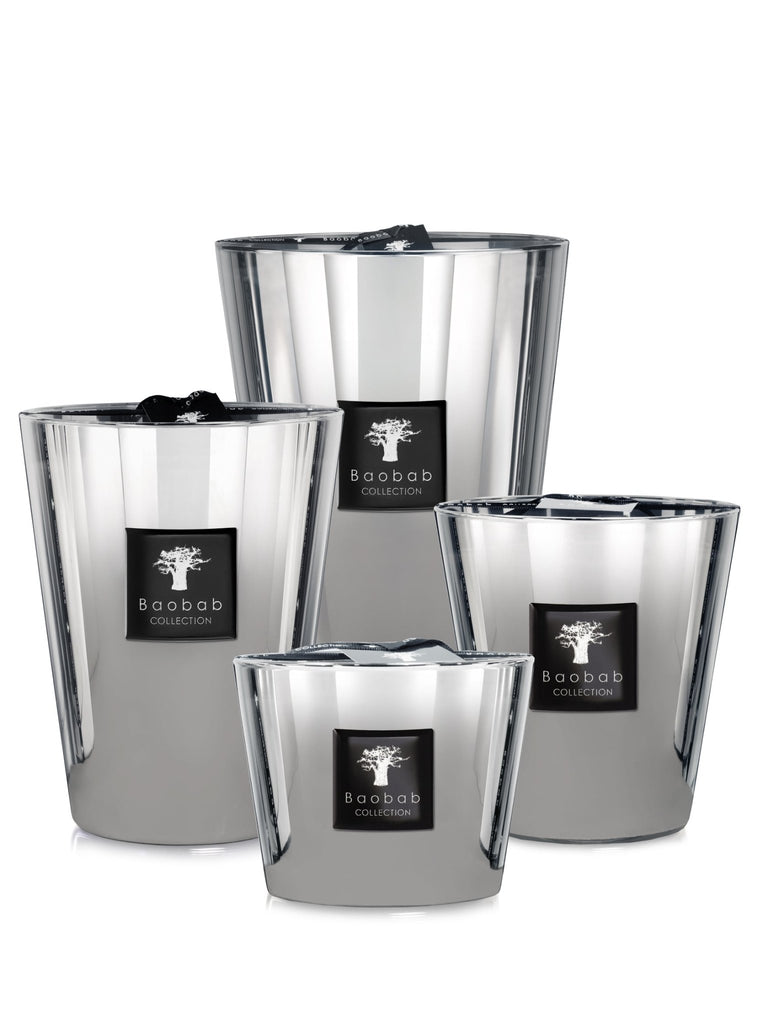 Four Baobab - Les Exclusives Platinum Max 16 reflective candles, each with a tree logo and Baobab Collection text, release an amber fragrance. Ideal for a soothing ritual, these platinum-scented candles are elegantly arranged on a white background.