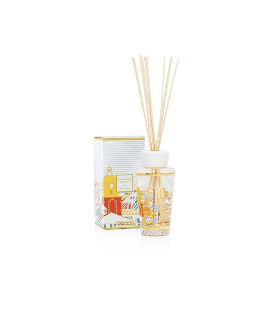 The Baobab - My First Baobab A Saint-Tropez 8.45oz Reed Diffuser set includes a glass bottle containing fragrant liquid, long wooden reeds, and features colorful Saint Tropez-inspired designs. It comes with a matching decorative box showcasing the same vibrant pattern.