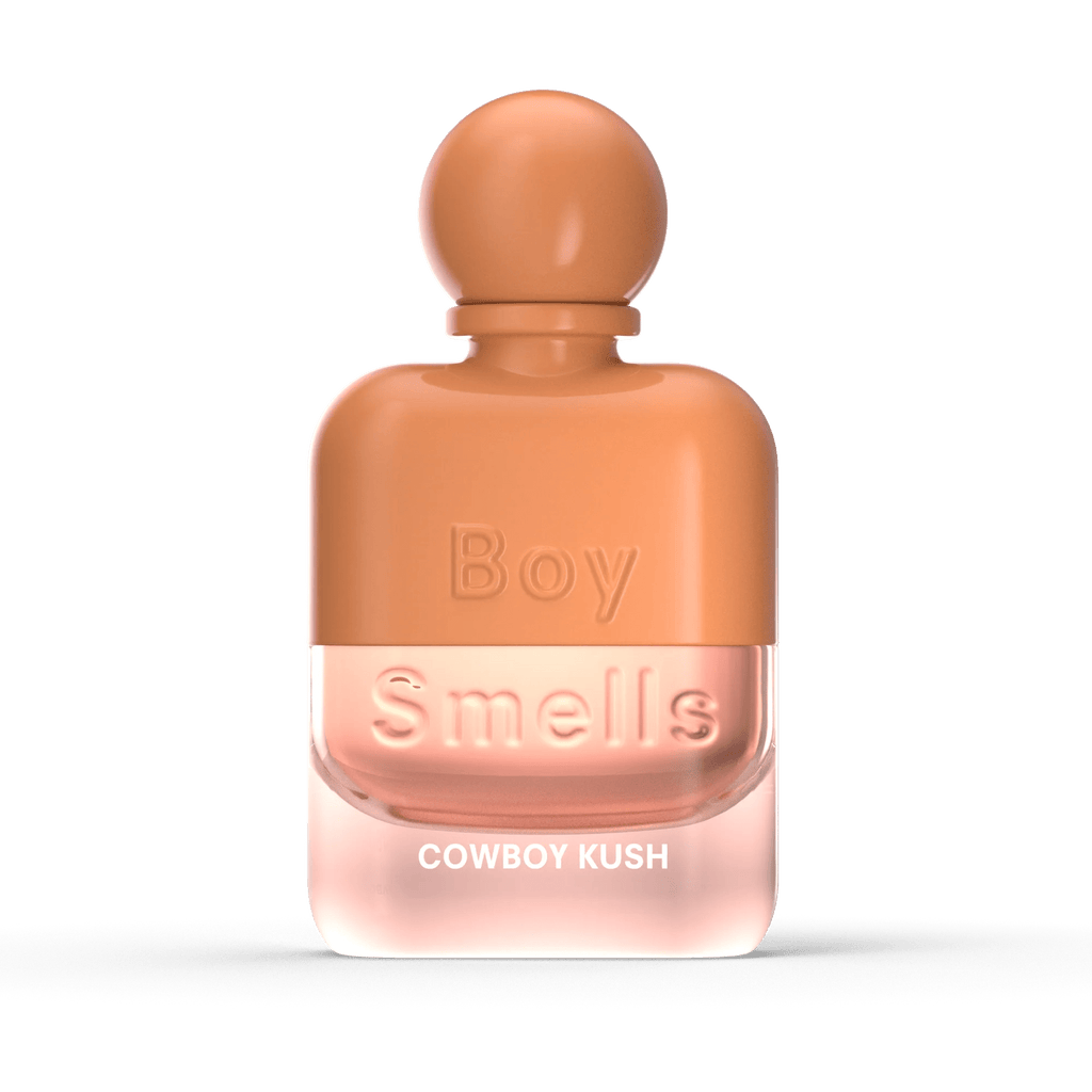 A sleek, peach-toned rectangular bottle of Boy Smells - Cowboy Kush Eau de Parfum 50ml features smooth edges and earthy spice with patchouli notes, set against a bold black background.