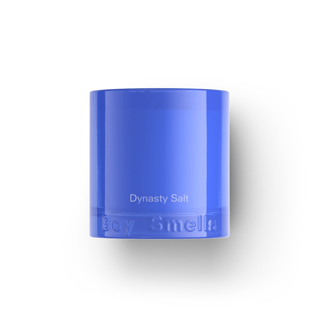 The Boy Smells - Dynasty Salt 8.5oz Candle features a bright blue wax in a translucent glass holder with the brand embossed at the base, emitting fresh clean musks, styled on a plain white and black background.