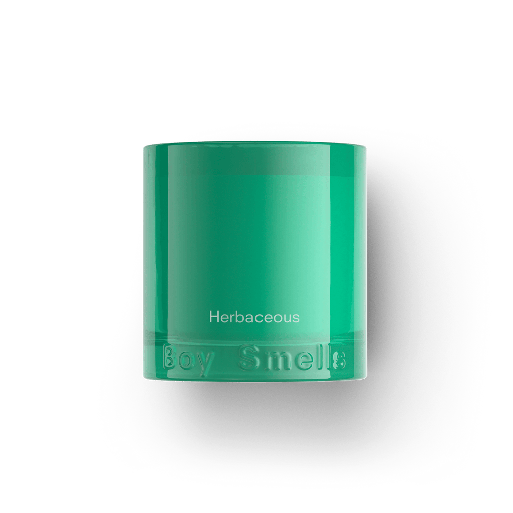 The Boy Smells - Herbaceous 8.5oz Candle features green glass and Herbaceous lettering, with notes of sage and bergamot, and the Boy Smells brand embossed at the base, shown on a plain white background.