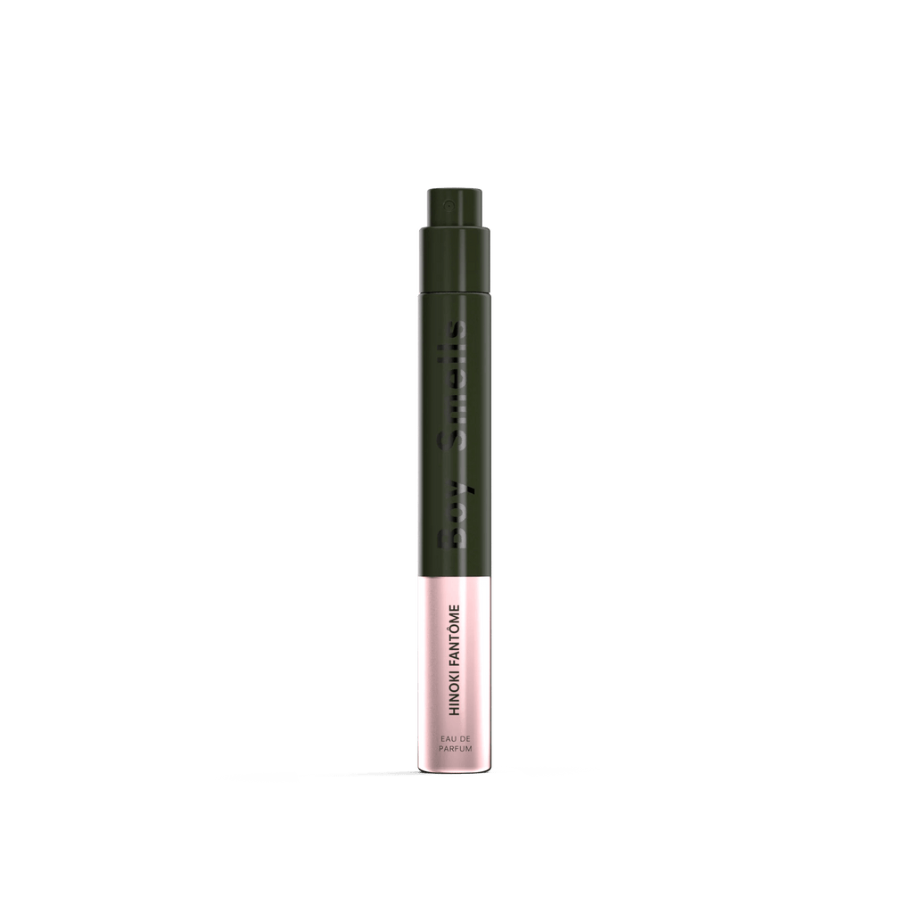 A slim, cylindrical fragrance pen with a black cap and upper body, and a light pink lower section labeled Hinoki Fantom in black. Boy Smells brand name appears vertically, suggesting notes of smoked amber for added intrigue.
