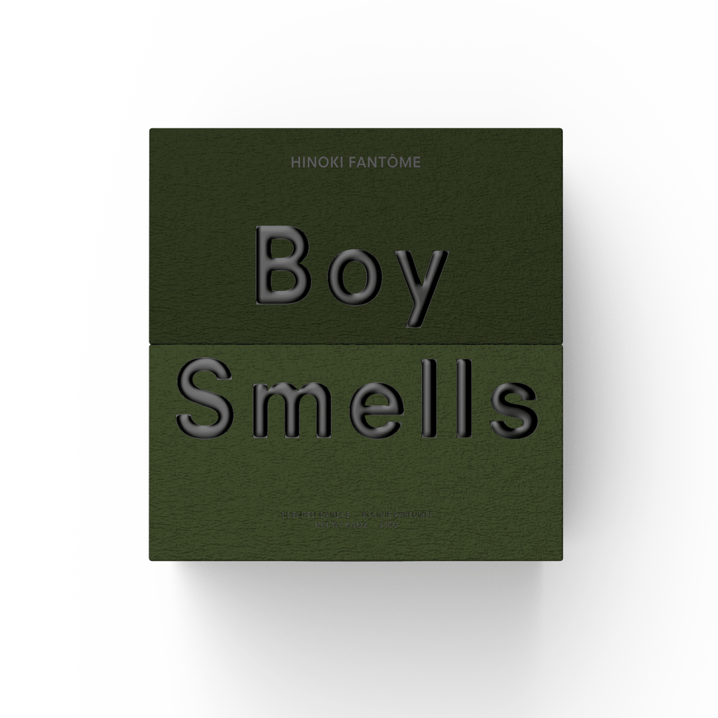 A green textured box with embossed black “Boy Smells” text and “Hinoki Fantome” above hints at the woody-spicy scent inside. Centered on white, the minimal design evokes luxury for Boy Smells Hinoki Fantome 27oz Candle.