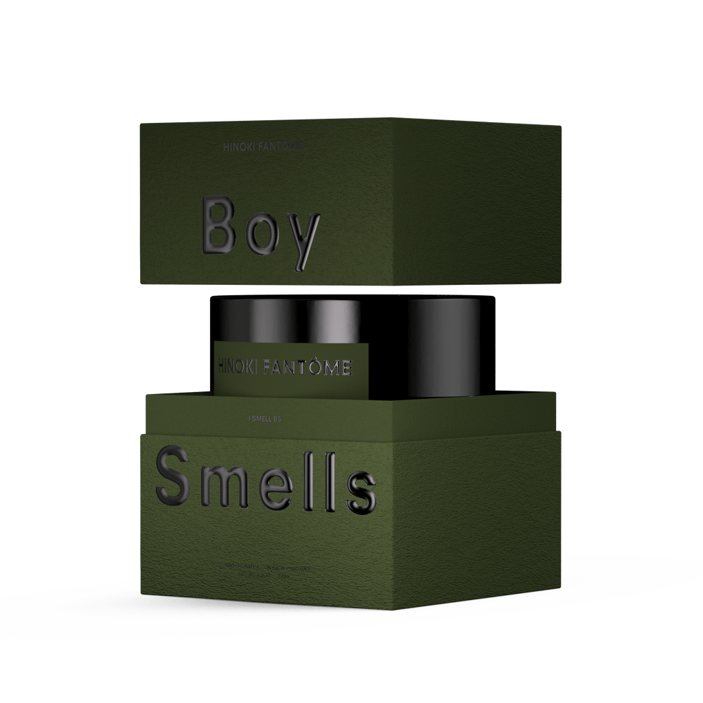 A dark green Boy Smells box opens to reveal a black 27oz Hinoki Fantome candle with a woody spicy scent, set against a white background.