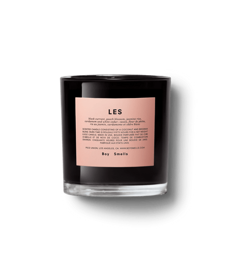 The Boy Smells - LES 8.5oz Candle in a black glass holder features a pink label detailing the fruity/floral scent and brand information, including Boy Smells at the bottom. This genderful candle, set against a white background, invites cross-cultural appreciation.