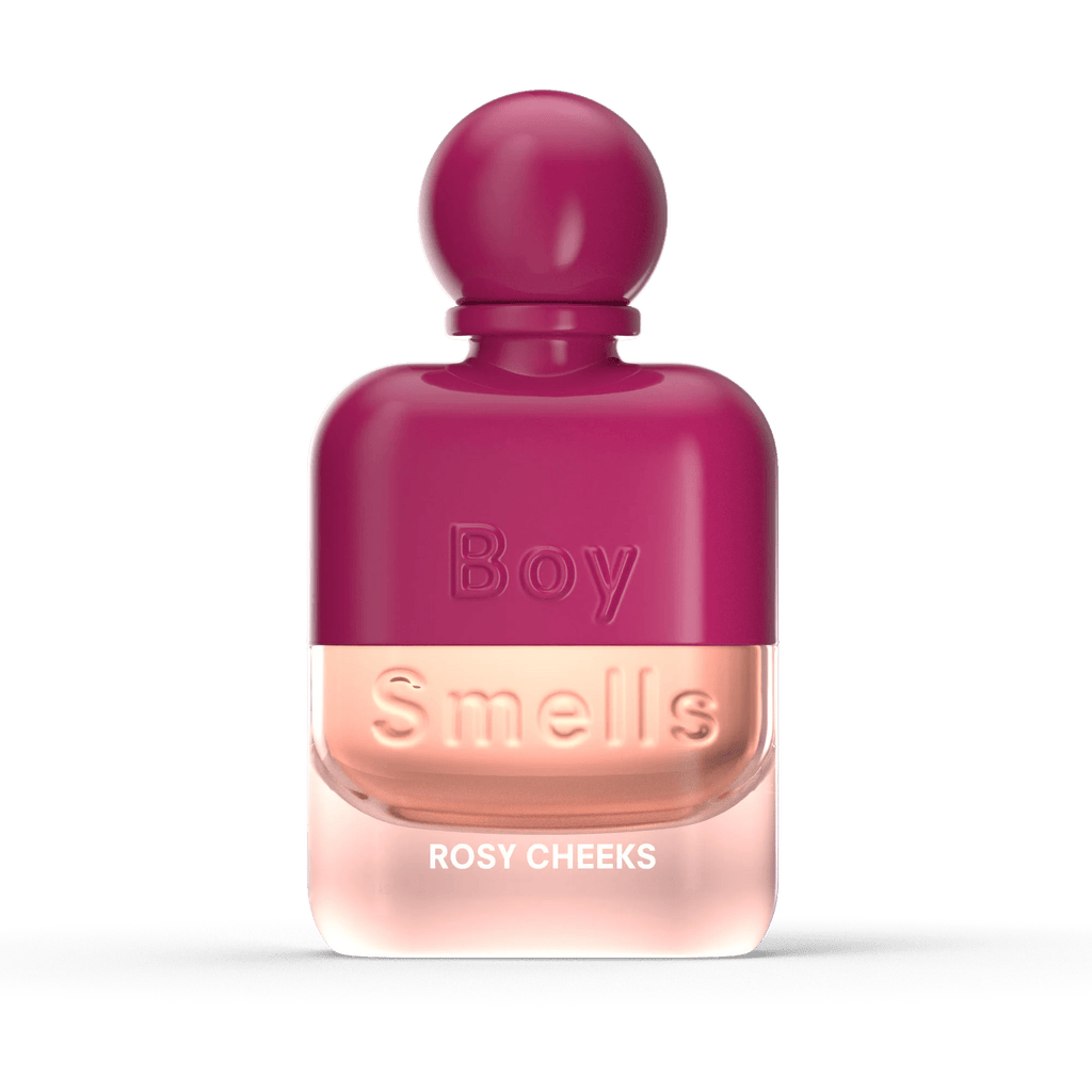 The Boy Smells - Rosy Cheeks Eau de Parfum 50ml features a pink gradient bottle with rounded cap, labeled with the brand and scent name. It evokes notes of rose and sandalwood.