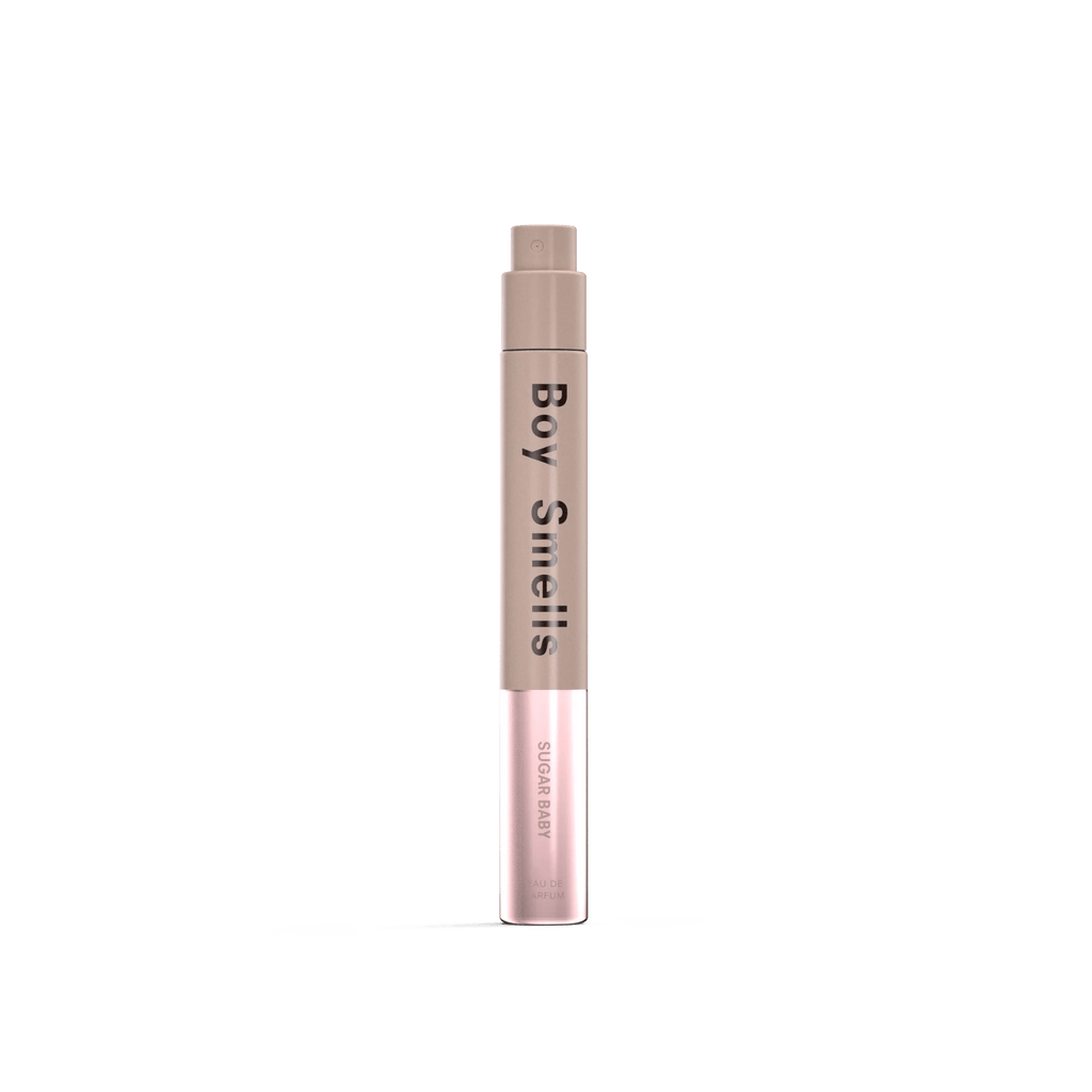 A cylindrical 10ml Boy Smells - Sugar Baby Eau de Parfum bottle with a brown cap fades to light pink at the base, standing upright against a white background, suggesting notes of honeysuckle and musk.
