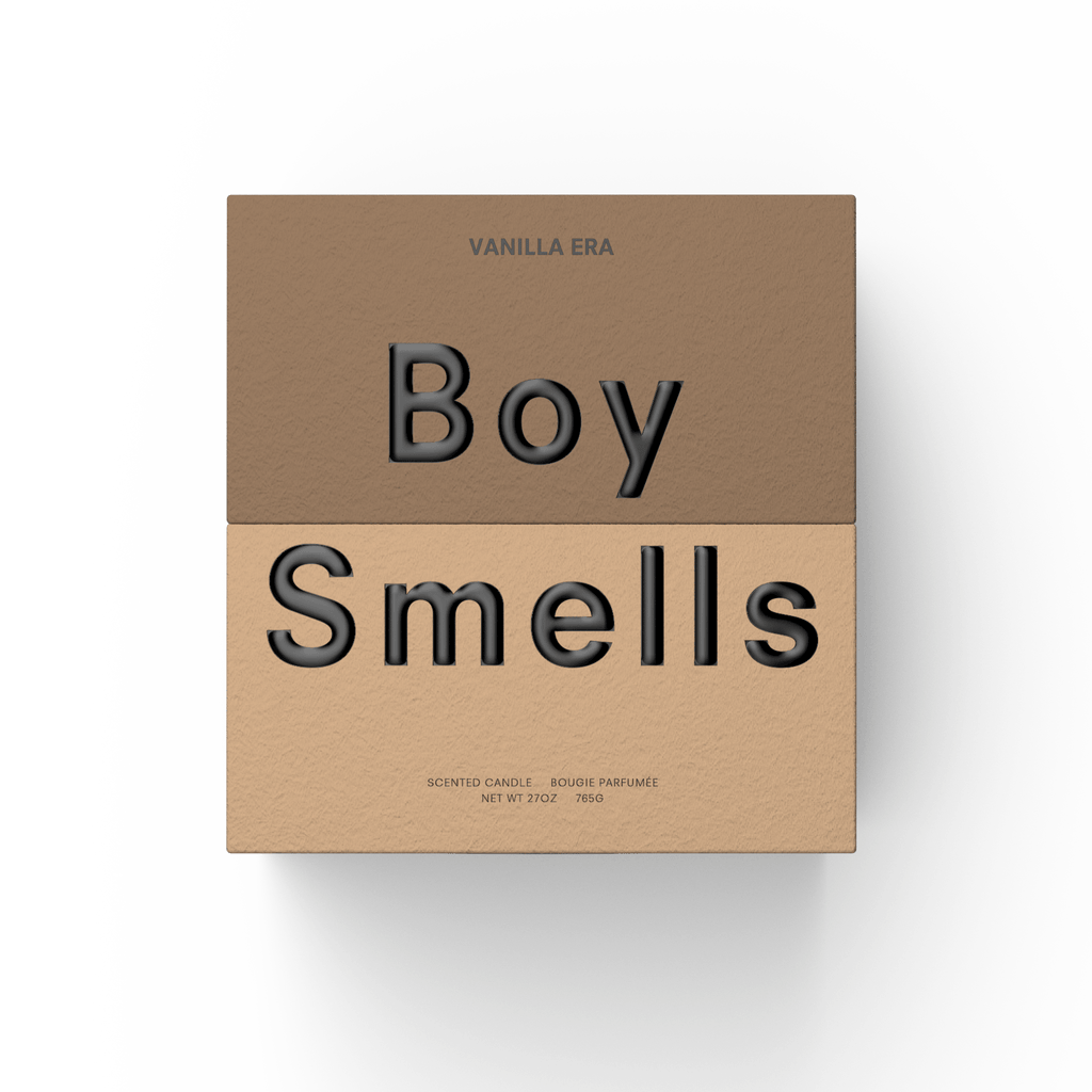 A square box in two brown shades features "VANILLA ERA" at the top and bold "Boy Smells" across the middle, with small text describing the Boy Smells - Vanilla Era 27oz Candle as a gourmand-scented vanilla candle.