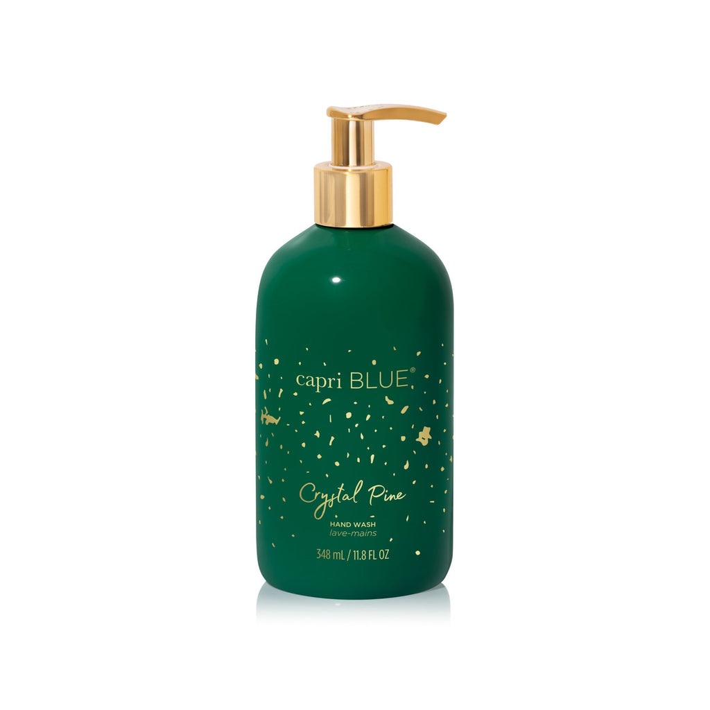 A green bottle of Capri BLUE - Crystal Pine Glimmer Hand Wash, featuring a gold pump and decorative gold dots, contains 348 ml (11.8 fl oz) of cruelty-free hand wash by Capri BLUE, displayed on a white background.