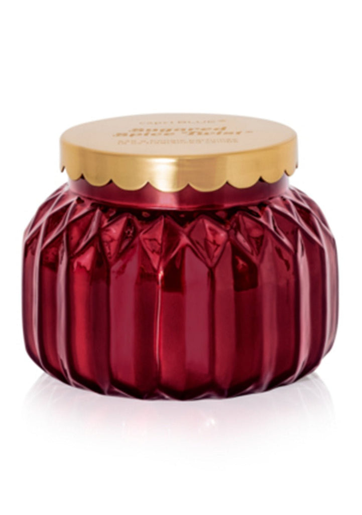 A decorative deep red glass jar with vertical ridges and a gold lid, perfect for holding the Capri BLUE - Sugared Spice Twist Signature Candle, 19oz—a stylish storage option for candles or cosmetics by Capri BLUE.