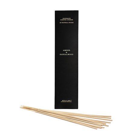 A tall, black rectangular box labeled Cereria Molla - Amber & Sandalwood Incense 20pk stands upright with long incense sticks arranged parallel on a white background, blending sandalwood and cedar harmoniously.