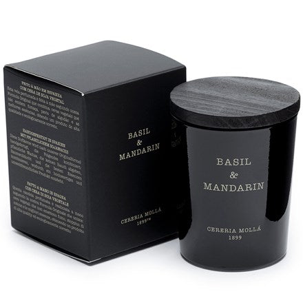 The handmade Cereria Molla – Basil & Mandarin 2.47oz Candle, elegantly embossed with the brands name, comes with a stylish wooden lid and is accompanied by a matching black box featuring the same text for added sophistication.