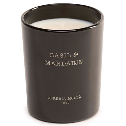 The Cereria Molla Basil & Mandarin 2.47oz candle, elegantly presented in a handmade black holder with white wax, features the Basil & Mandarin and Cereria Mollà 1899 labels on the front, adding a sophisticated touch to any space.