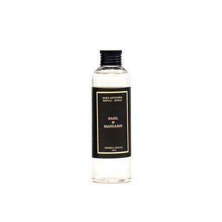 A clear bottle with a black label features Cereria Molla - Basil & Mandarin 6.7oz Diffuser Refill, infused with citrus notes, holding a light-colored liquid sealed with a black cap and set against a plain white background.