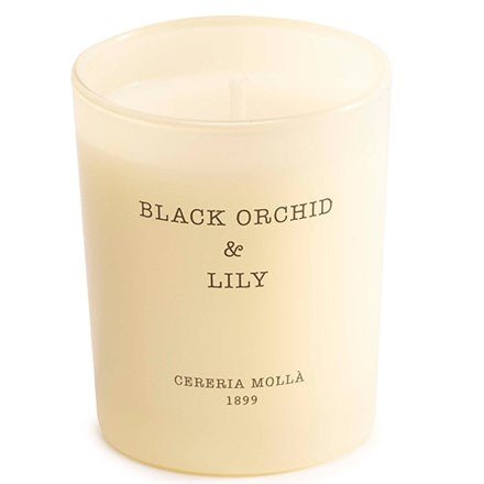 A cream-colored vegetable wax candle named Black Orchid & Lily by Cereria Molla is in a frosted glass jar.