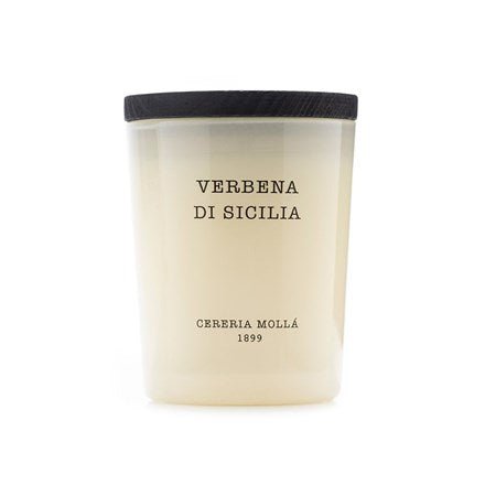 A white scented candle made from premium soy wax sits in a glass jar with a black lid. The label reads Verbena De Sicilia and Cereria Molla, adding Sicilian charm.