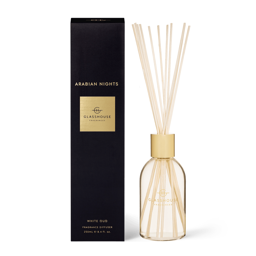 Glasshouse Fragrances Arabian Nights diffuser features a 250ml clear bottle with gold labeling, exotic white oud and saffron essence, and elegant reed sticks, all packaged in a sleek black box for a luxurious ambiance.