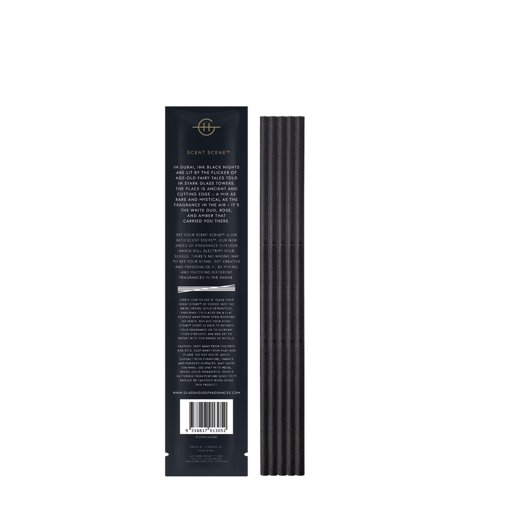 The Glasshouse Fragrances Arabian Nights Replacement Scent Stems comes in a tall black box, featuring vertical grooves and poetic detailing inspired by exotic tales. Its description highlights hints of saffron and the enchanting allure of white oud.