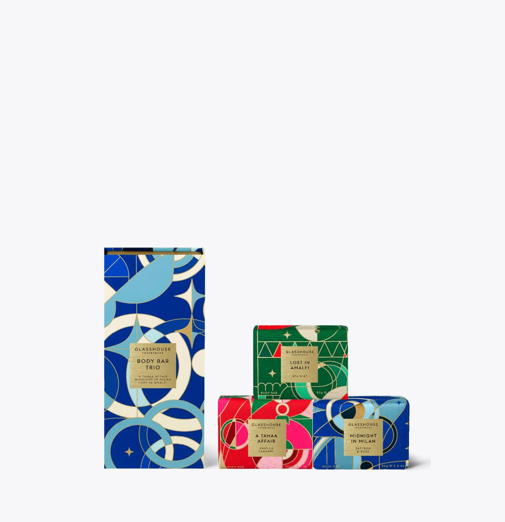 Glasshouse Fragrances - Body Bar Trio includes a tall blue box labeled French triple-milled Body Bar and two smaller luxury gift boxes, one green and one red, all adorned with abstract geometric designs and offering assorted fragrances.