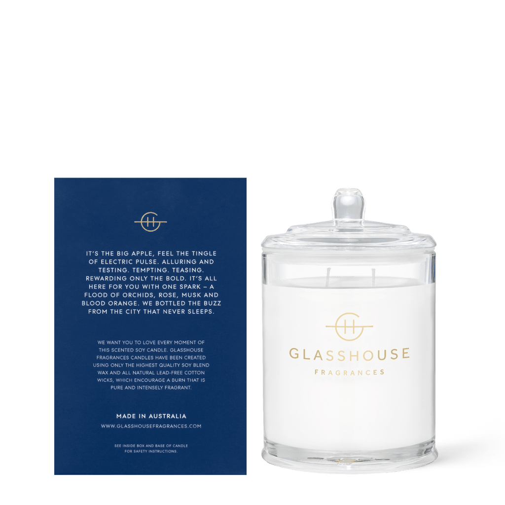 A Glasshouse Fragrances - I’ll Take Manhattan 13.4oz Candle features a blue card detailing its exotic orchid scent. Made in Australia, this luxurious soy blend wax candle ensures a clean, fragrant burn.