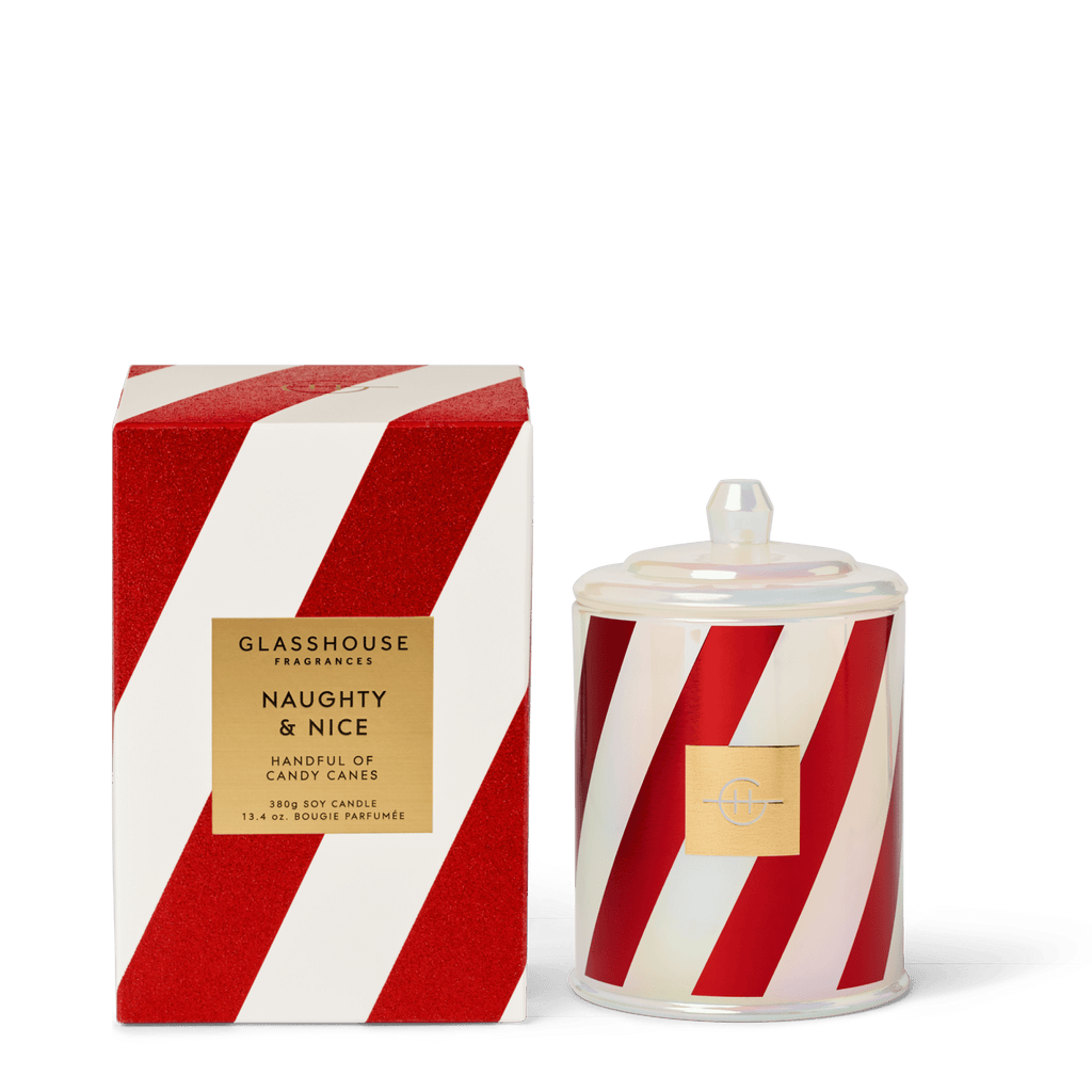 The Glasshouse Fragrances - Naughty & Nice Candle features festive red and white stripes with a gold label and candy cane design. This soy blend holiday candle comes in a matching box—perfect for seasonal gifting or decorating.