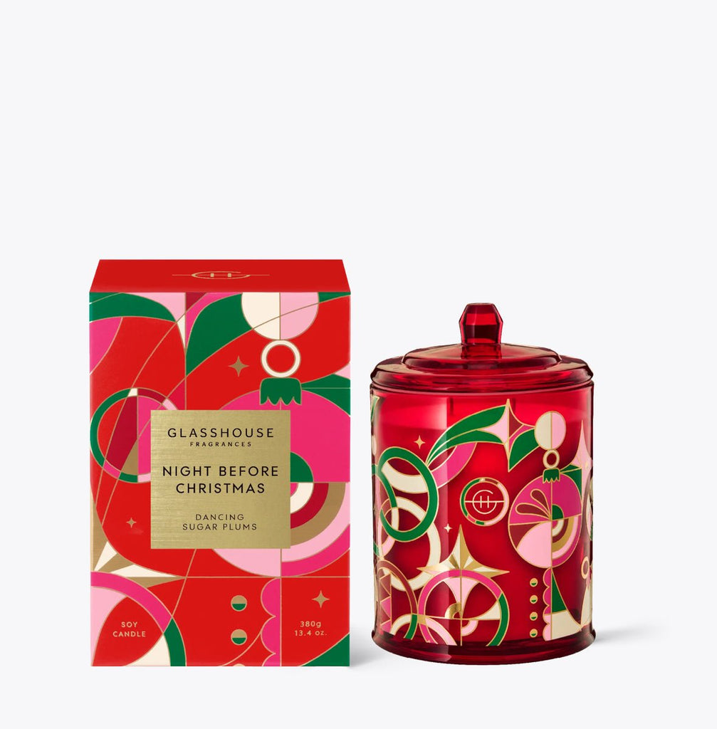 The Glasshouse Fragrances - Night Before Christmas 13.4oz Candle features festive packaging and a jar with red, green, and gold abstract designs. The soy-blend wax candle offers a delightful holiday fragrance.