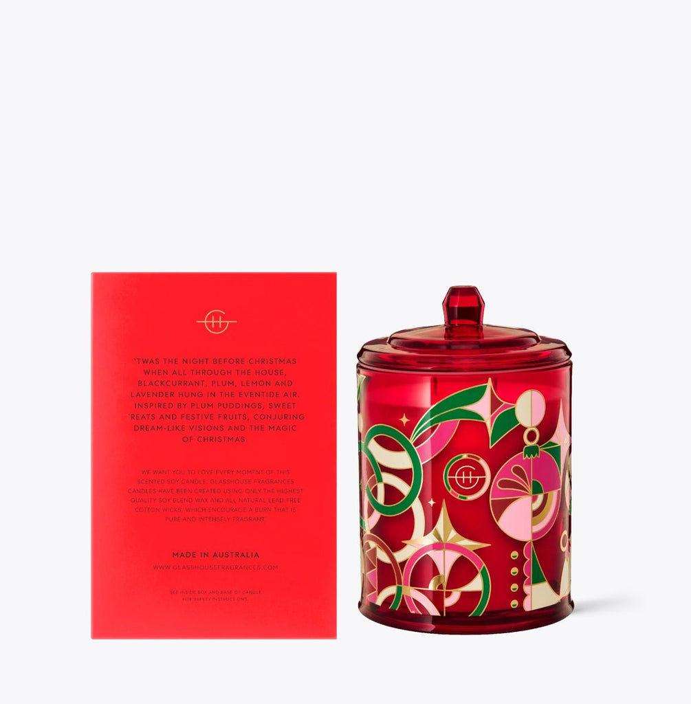 The Glasshouse Fragrances - Night Before Christmas 13.4oz Candle, crafted from soy blend wax, features festive holiday designs like abstract ornaments and green leaves. Paired with a matching red card with gold letters, this candle by Glasshouse Fragrances adds charm to any festive setting.