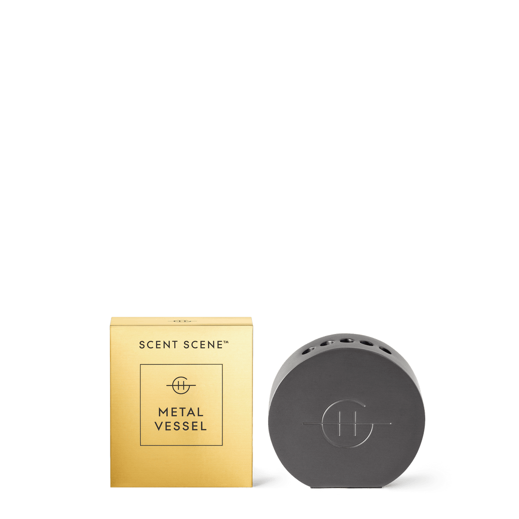 A sleek, round gunmetal stand by Glasshouse Fragrances is designed for fragrance lovers as a liquidless Scent Scene diffuser holder that pairs perfectly with Scent Stems. The minimalist brand logo is elegantly engraved on the front.