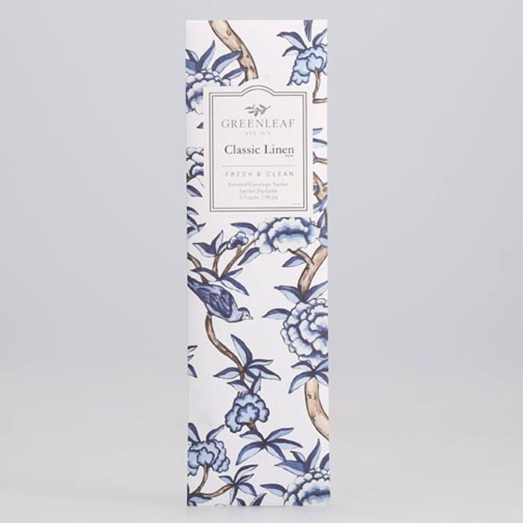 A tall, rectangular sachet package features a floral design in shades of blue. Labeled Greenleaf - Classic Linen Sachet, it highlights Greenleafs signature scent, described on a plain light gray background.