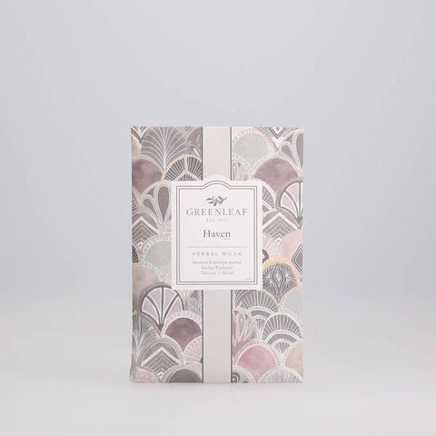 The Greenleaf - Haven Sachet features a design of overlapping pastel shells in purple, pink, and gray. A center label displays the brand name and product details, making it a captivating large sachet from Greenleaf.