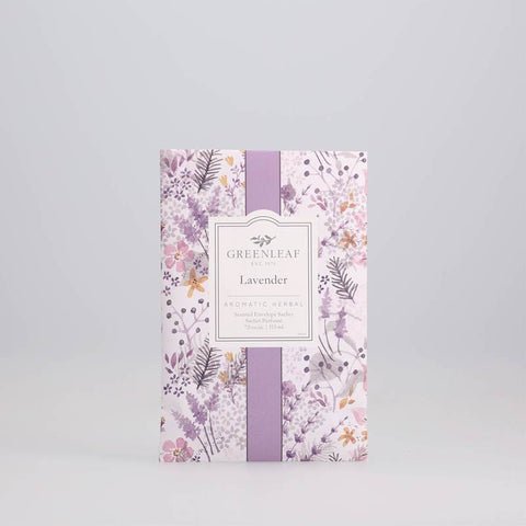 The Greenleaf - Lavender Sachet releases a lovely floral scent. Its packaging features an elegant design with purple, pink, and yellow flowers and leaves. A label in the center reads Lavender, providing details about this delightful fragrance from Greenleaf.