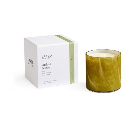 A green glass candle by Lafco, labeled Andean Myrtle, is beside a white box with a vertical green stripe. This artisan-made 15.5oz candle is infused with the fresh scent of Schinus Molle, ideal for aromatherapy.