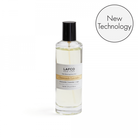 A clear glass bottle of Lafco - Chamomile Lavender Room Mist features a black cap and new odor removing technology. The label showcases chamomile, lavender, and hints of bergamot. A circular badge in the top right corner says New Technology.