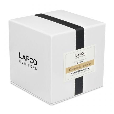 A white box with a black vertical stripe displays the Lafco brand and product name, Chamomile Lavender Signature 15.5oz Candle, offering an essential oil fragrance for a soothing chamomile lavender experience.