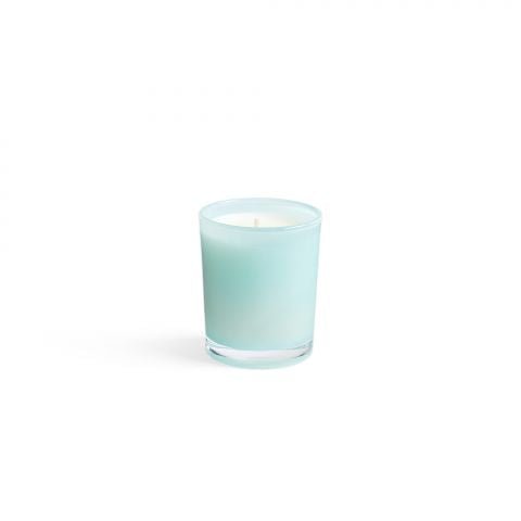 The Lafco - Marine 1.9oz Votive Candle in a frosted glass holder emits a soft glow with the gentle scent of sea jasmine, enhancing its simplicity and elegance against a plain white background.